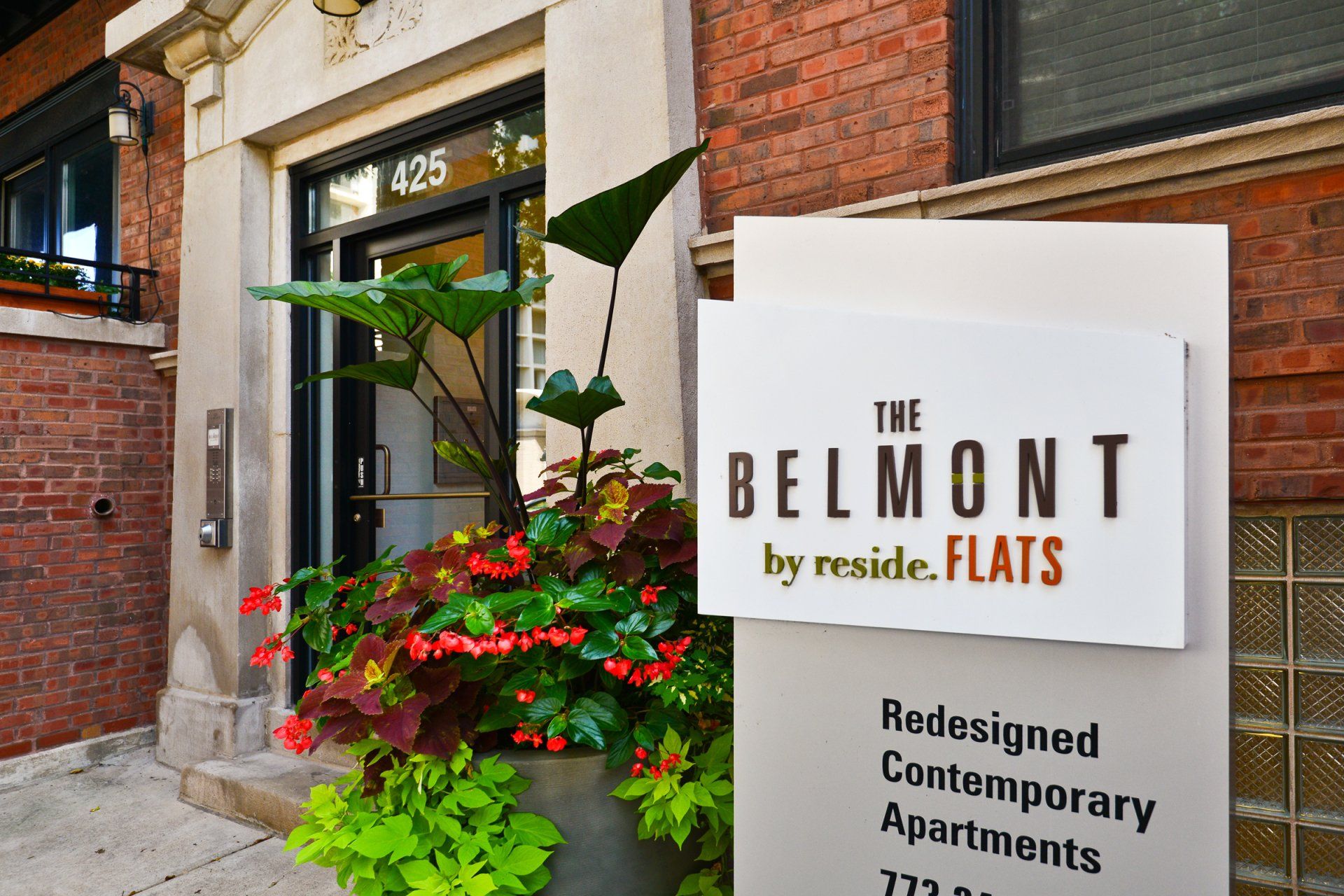 Apartment signage outside of the apartment building that says The Belmont by Reside Flats.