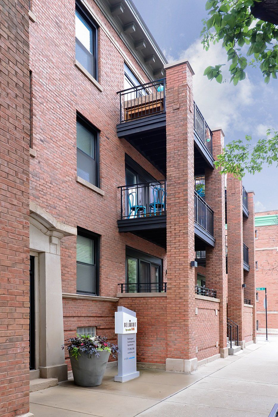 A brick building with balconies at The Belmont by Reside Flats.