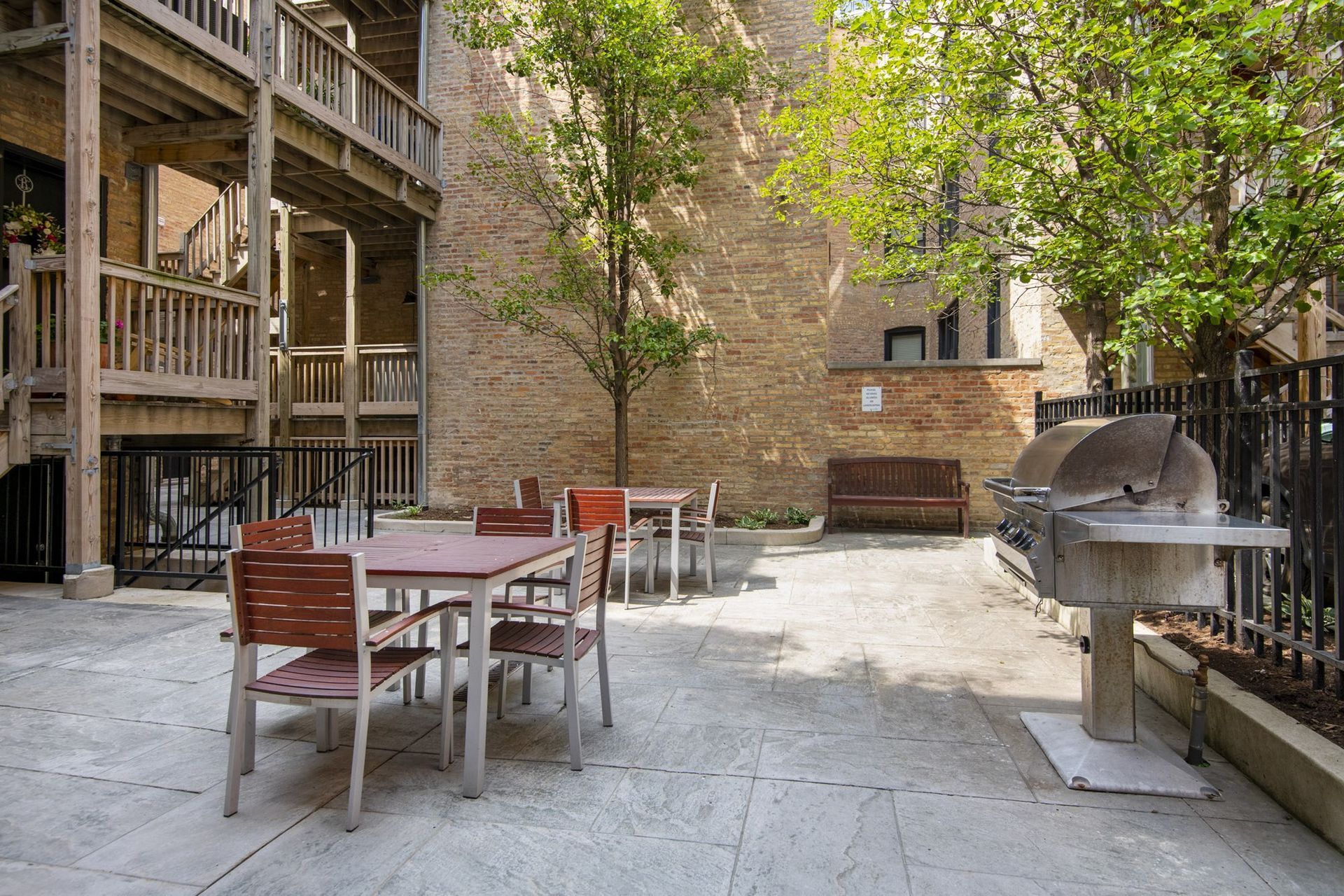 a patio with tables and chairs and a grill