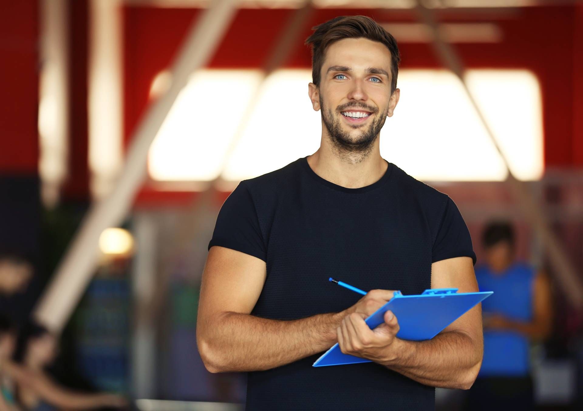 Personal trainer holding clipboard with training plan in gym near Lexington, Kentucky (KY)