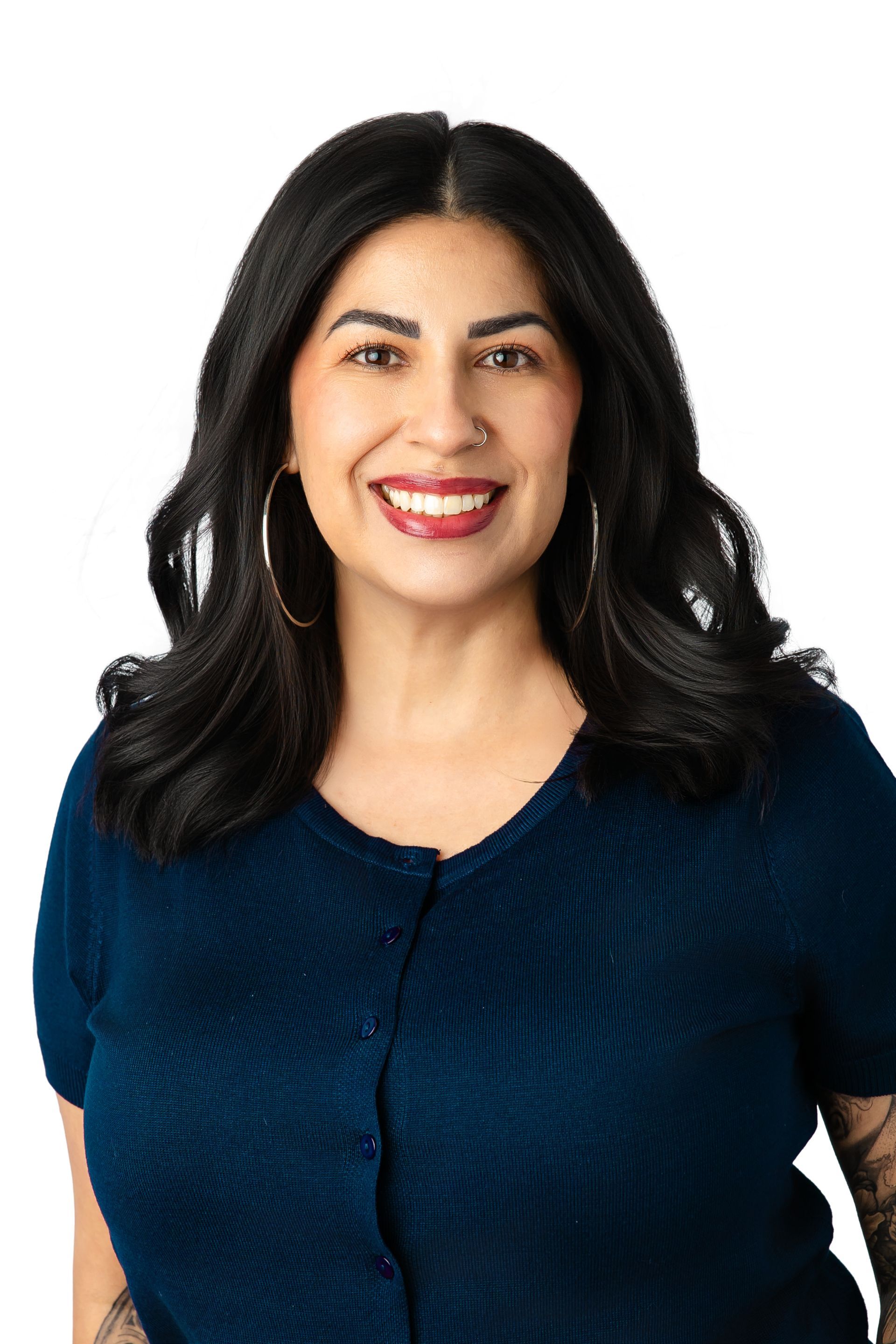 A woman in a blue sweater is smiling for the camera.