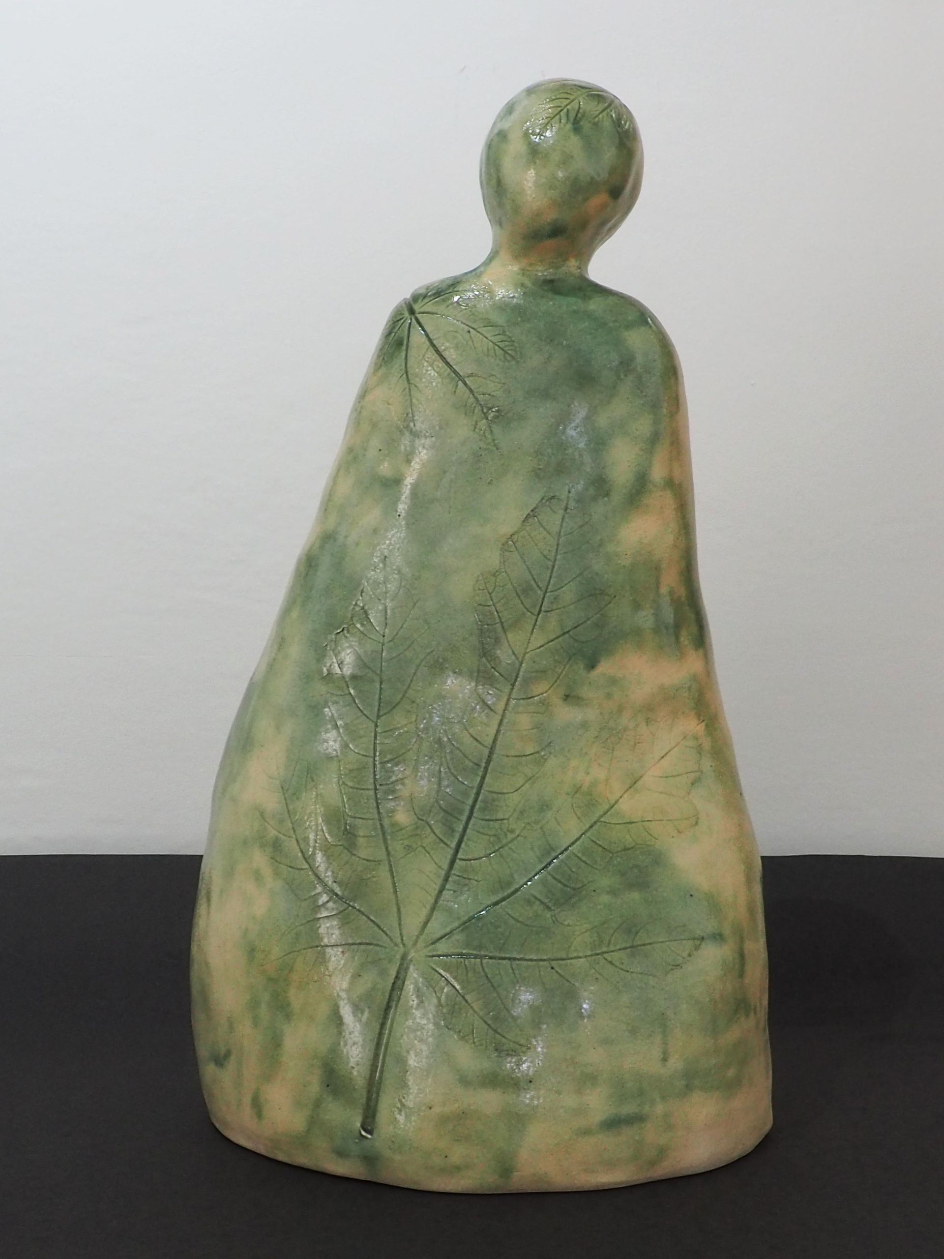 A ceramic simple green figure with a Fig Leaf imprint.