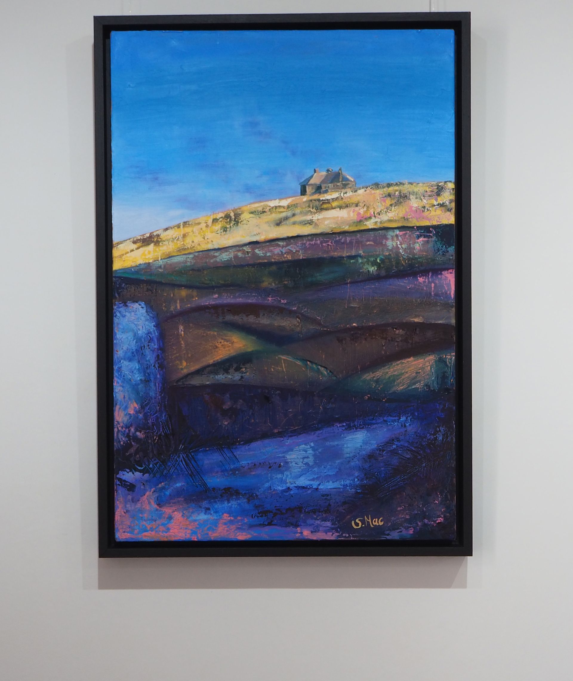 A hill made of dark curvy coloured shapes leading up to a golden slope  with a sunbathed house on it. The sky is blue and the foreground is blue, purples and pink - to the left - a path and a stone in the shade.