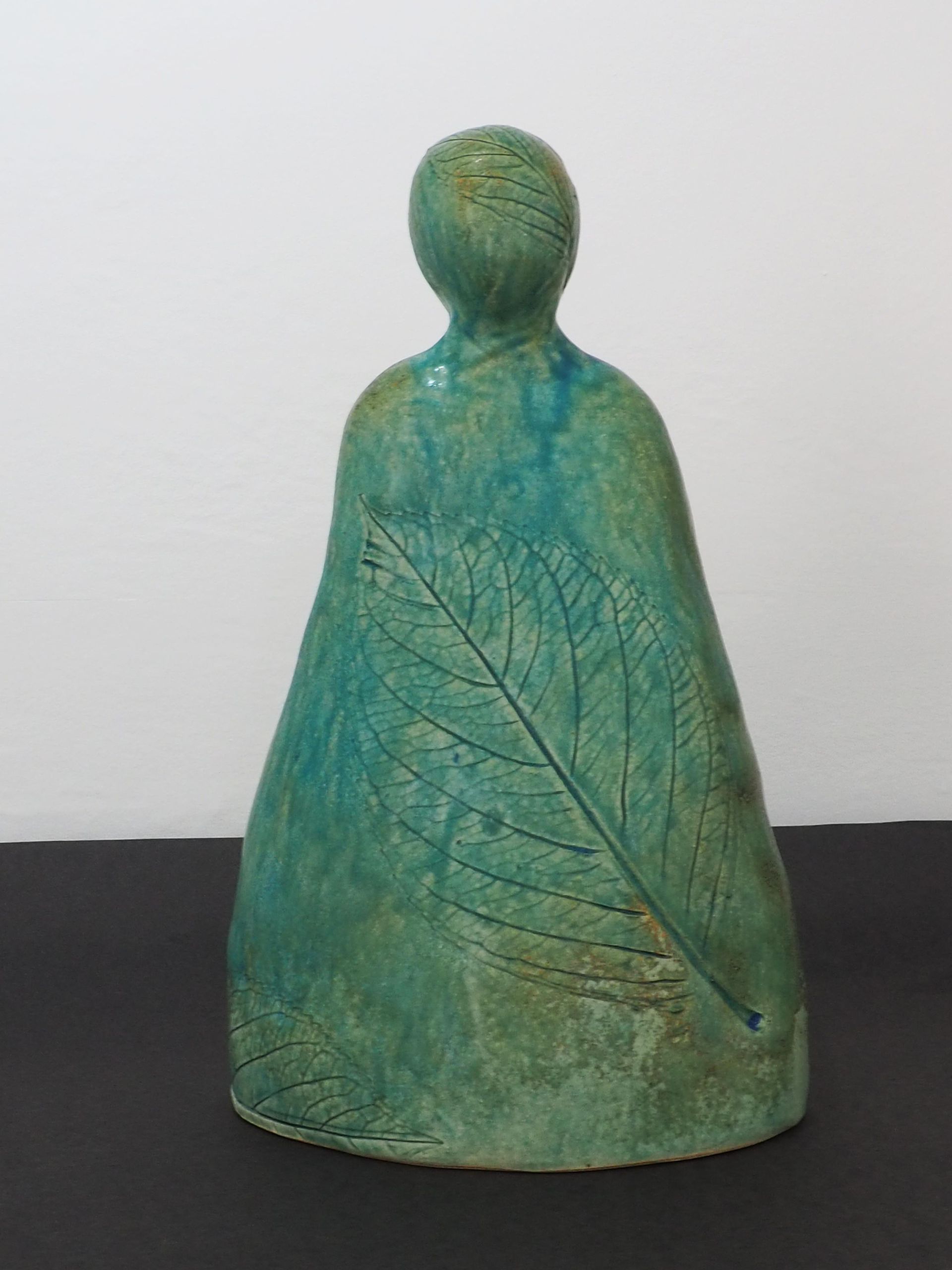 A ceramic simple green figure with a Hydrangea Leaf imprint.