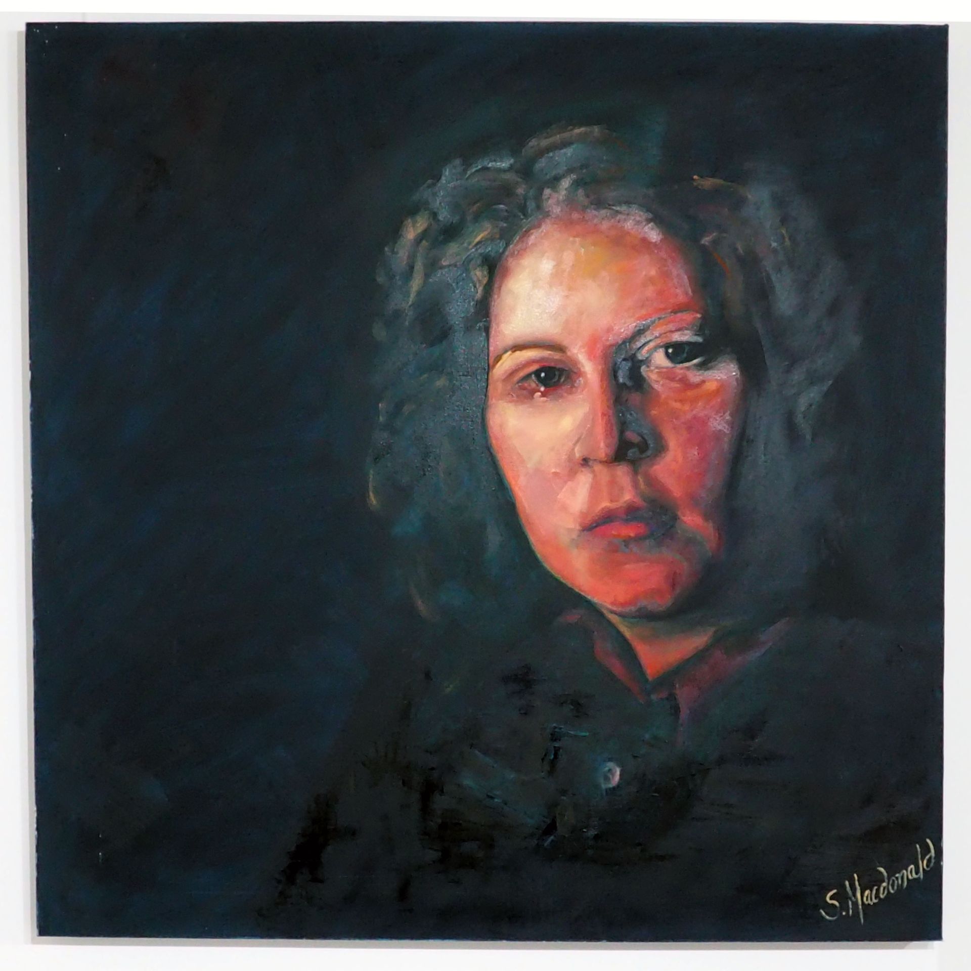 On a large dark square canvas emerges a warm sad face of the artist herself - Sarah Macdonald