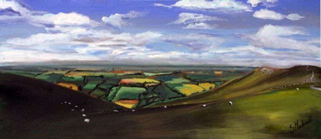 Landscape painting of partially shaded green hills looking down onto a patchwork of fields made of greens, golden yellow and terracotta  fading off to the horizon. The sky takes up 50% of the painting and is blue with fluffy clouds, also going off to the horizon. There are specks of white on the hills (sheep) and to the right Uffington White Horse.