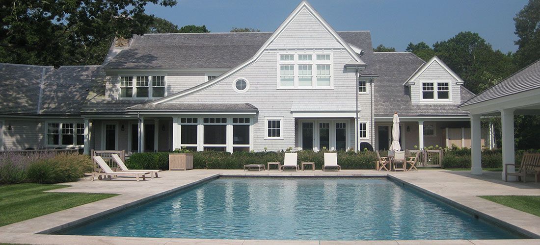 A large white house with a large swimming pool in front of it