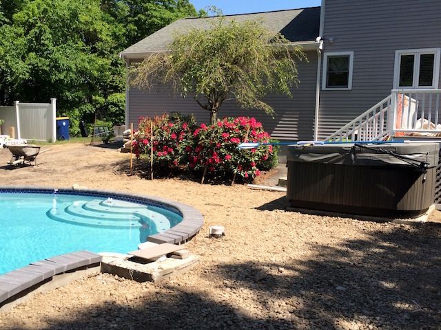 A swimming pool is being built in the backyard of a house.
