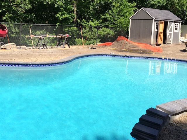A large swimming pool with a shed in the background.