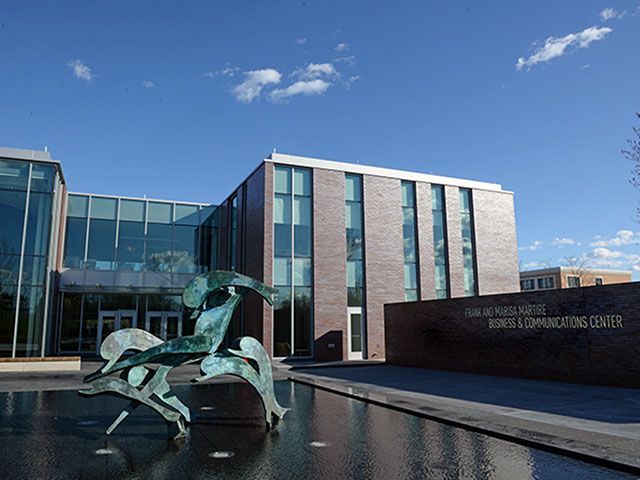 A large brick building with a statue of a horse in front of it