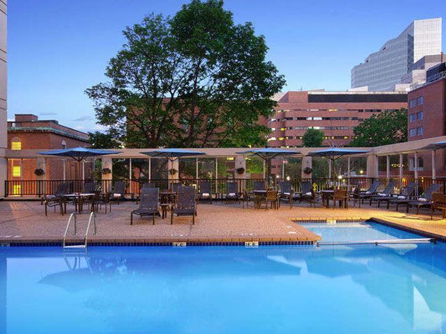 A large swimming pool with chairs and umbrellas around it