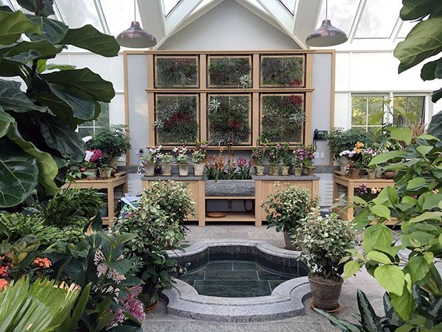 A greenhouse filled with lots of potted plants and flowers