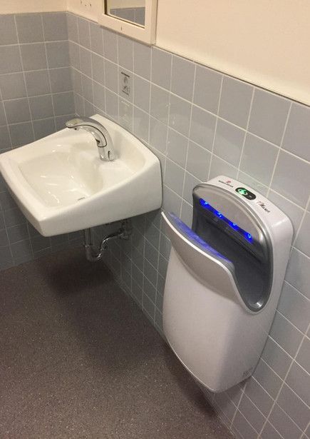 Une salle de bain avec un lavabo et un sèche-mains.
