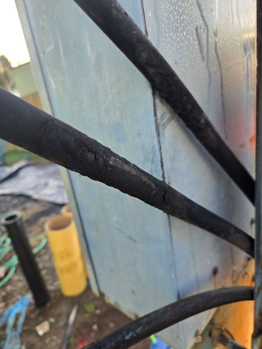 Three black cables against a light blue surface, one cable has visible damage.