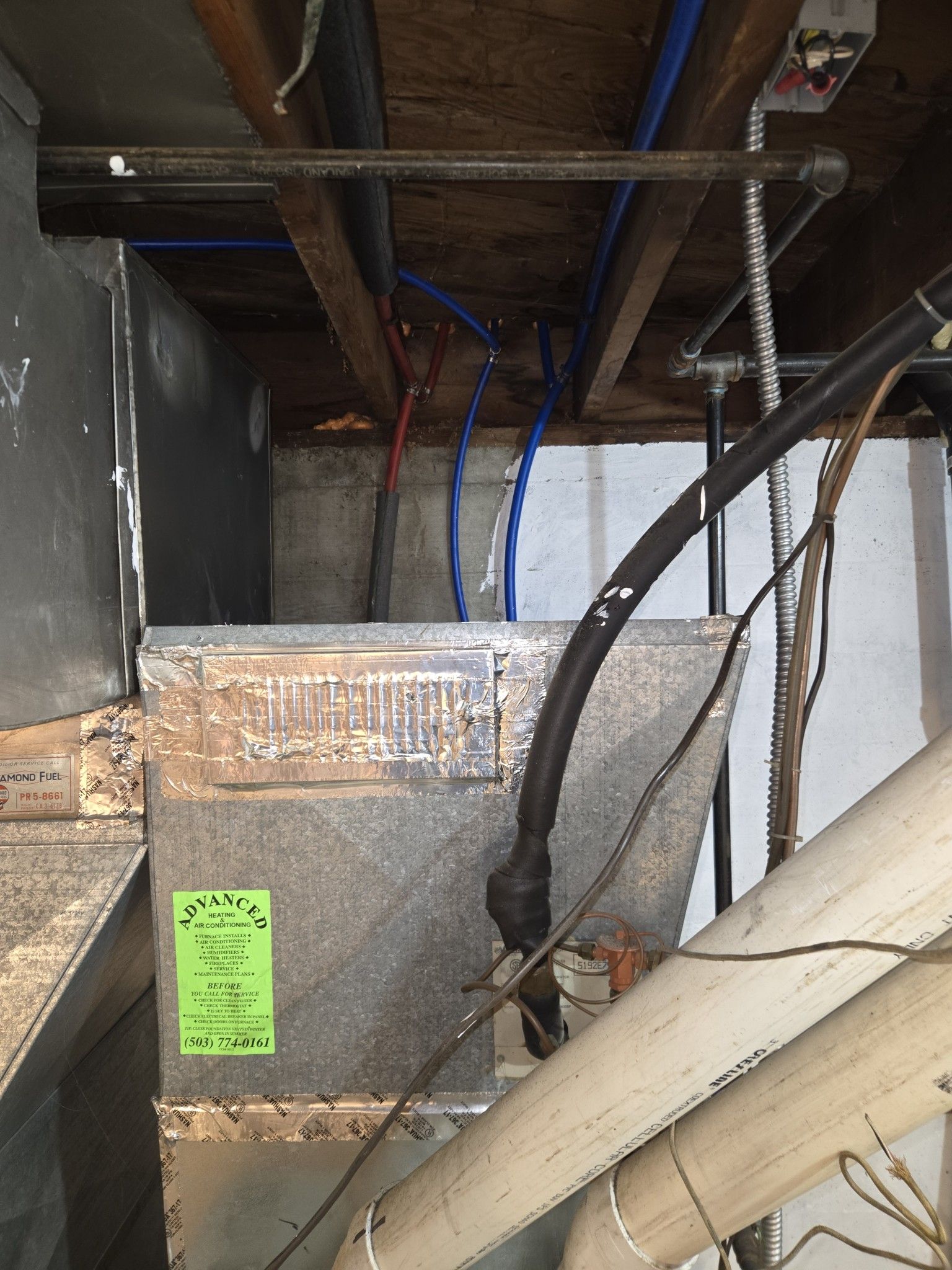 Galvanized metal ductwork in a basement, with PEX piping and other utility components overhead.