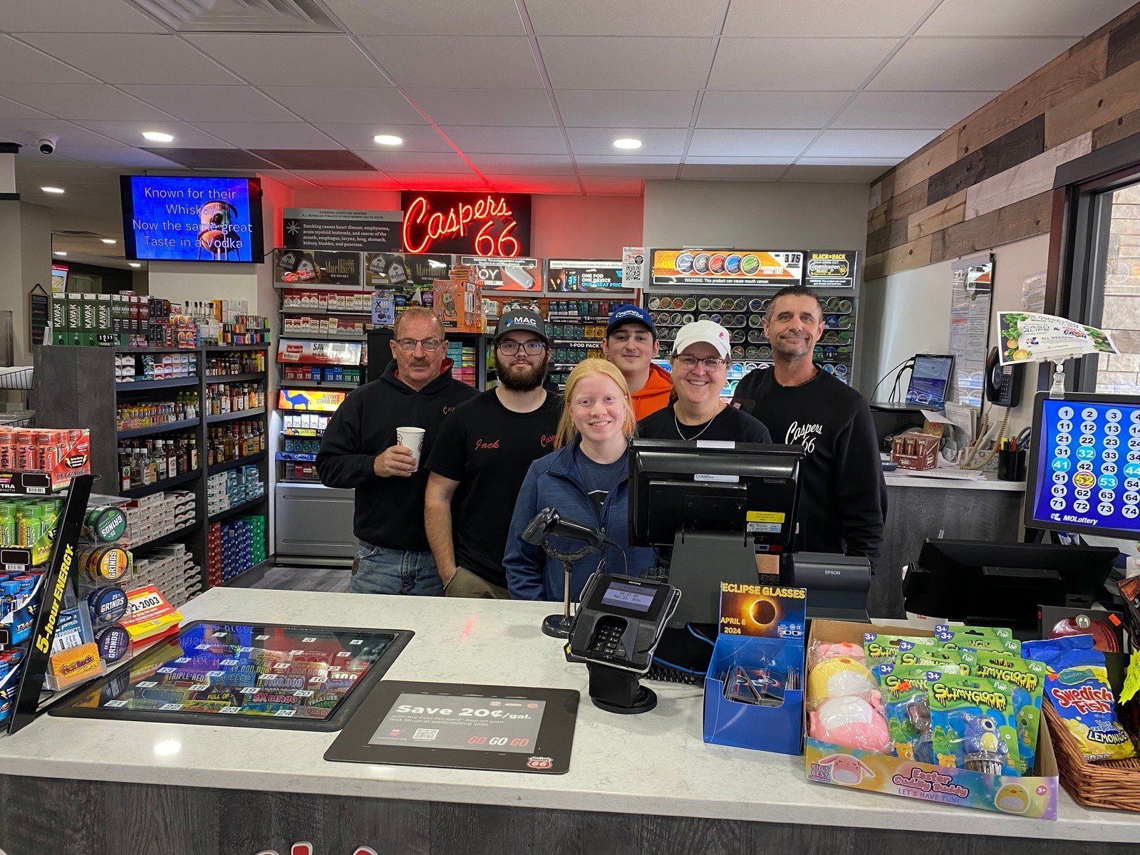 A group of people are standing behind a counter in a store.