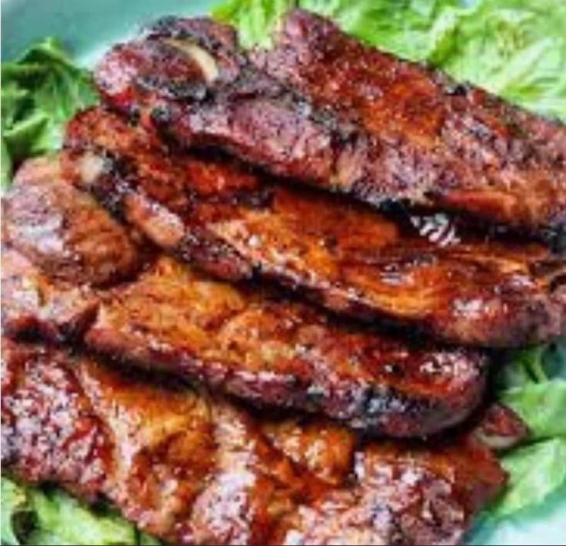 A close up of a plate of meat and lettuce on a table.