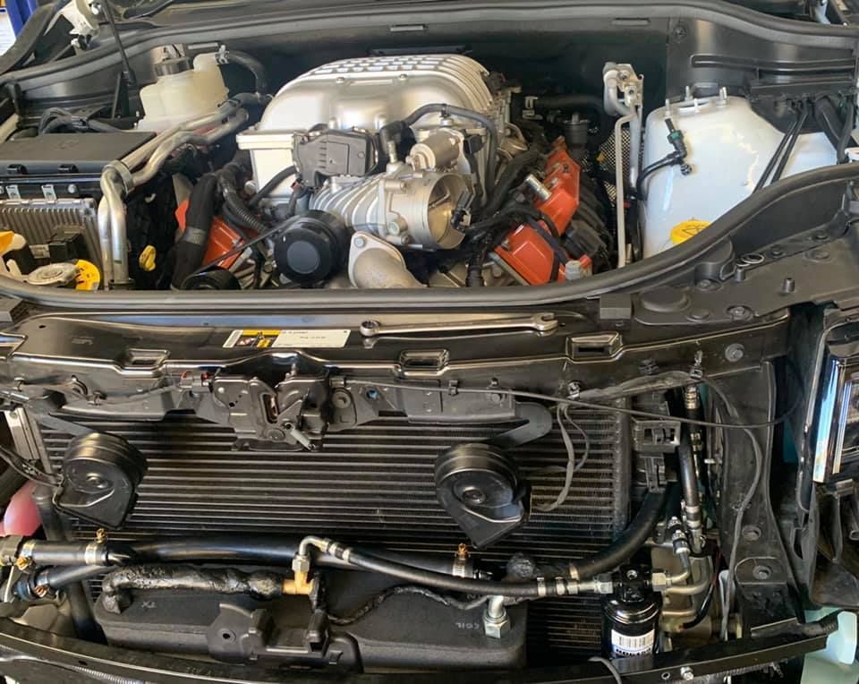 A close up of a car engine with the hood open