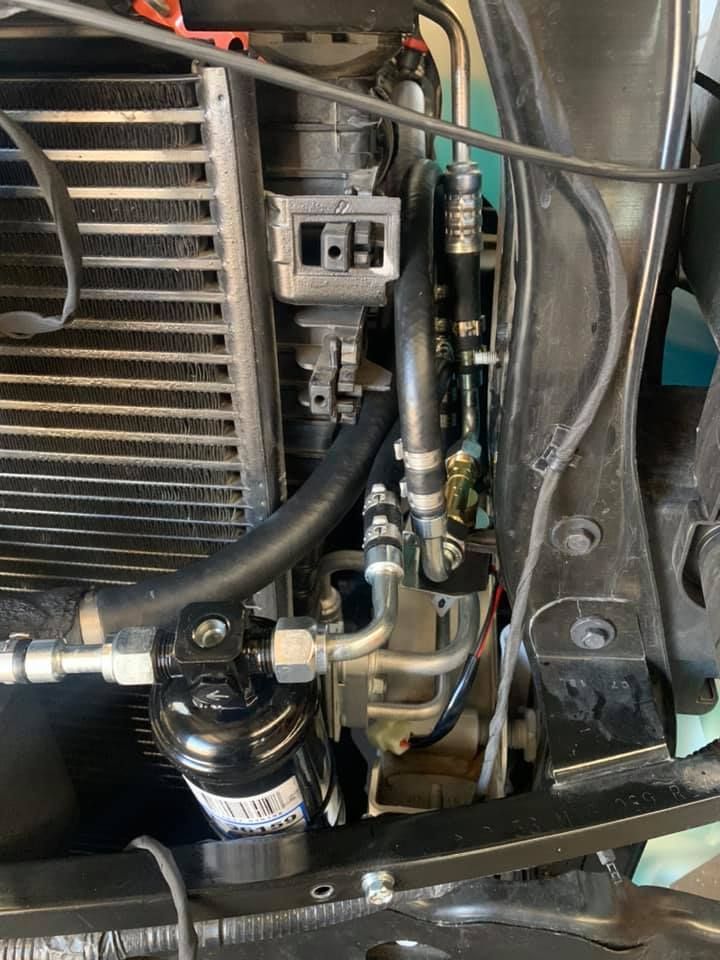 A close up of a car radiator with hose attached to it