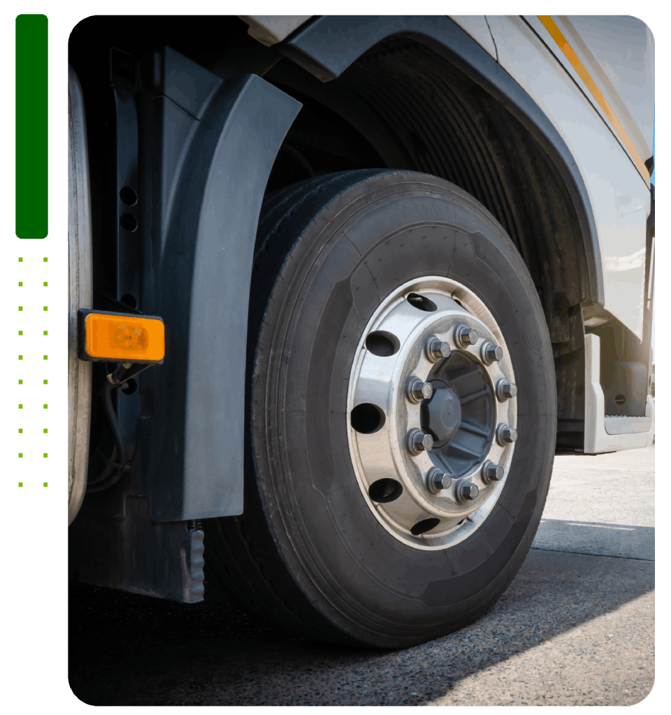 A close up of a truck 's tire on a road.