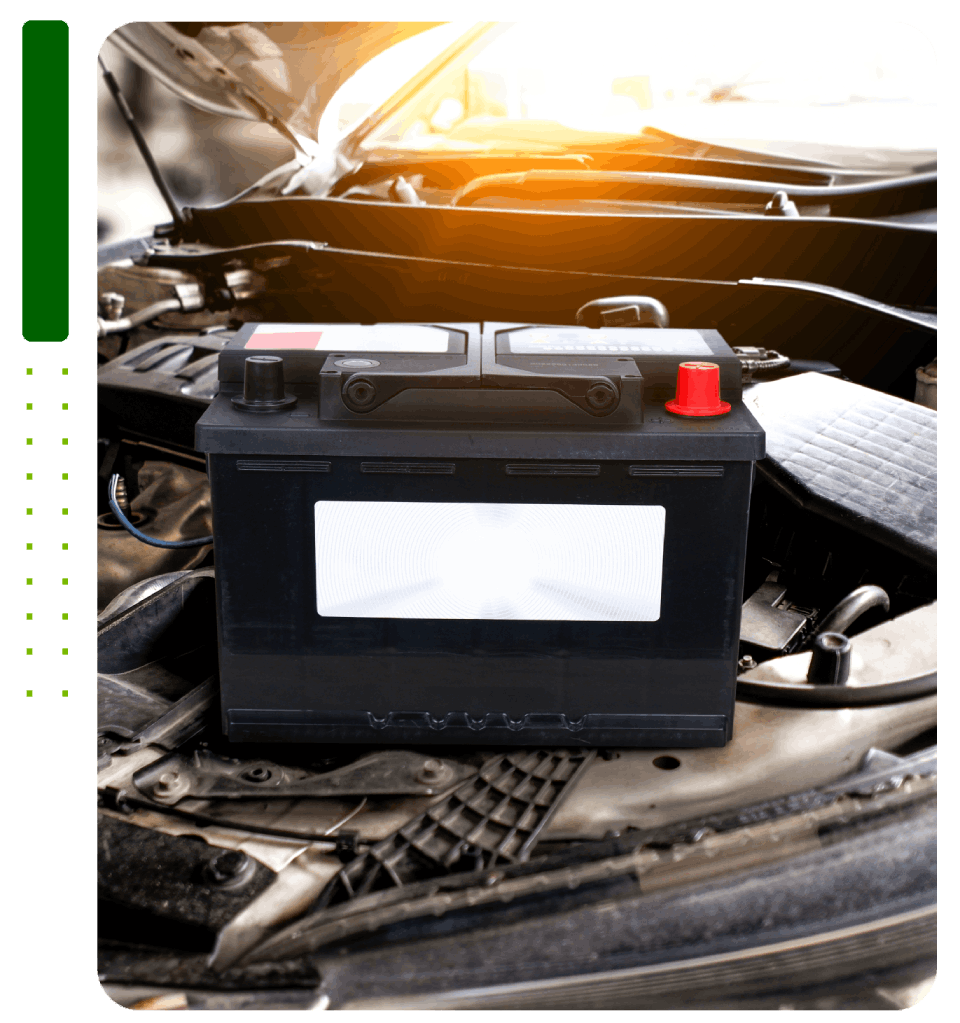 A car battery is sitting under the hood of a car.