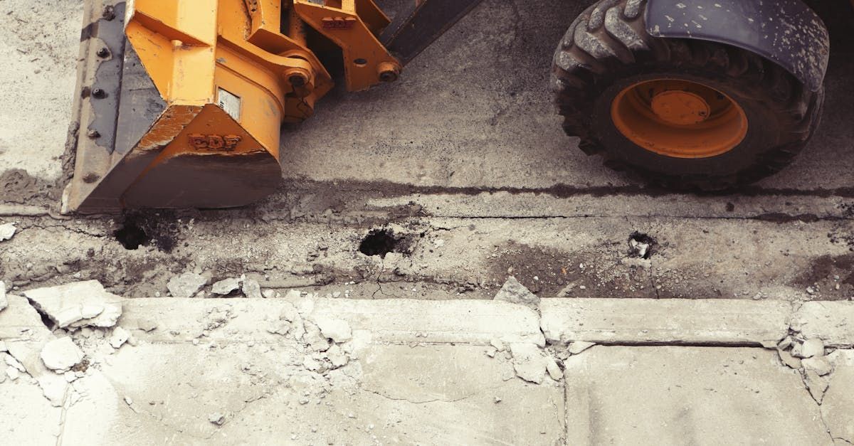 A bulldozer is working on a concrete surface.