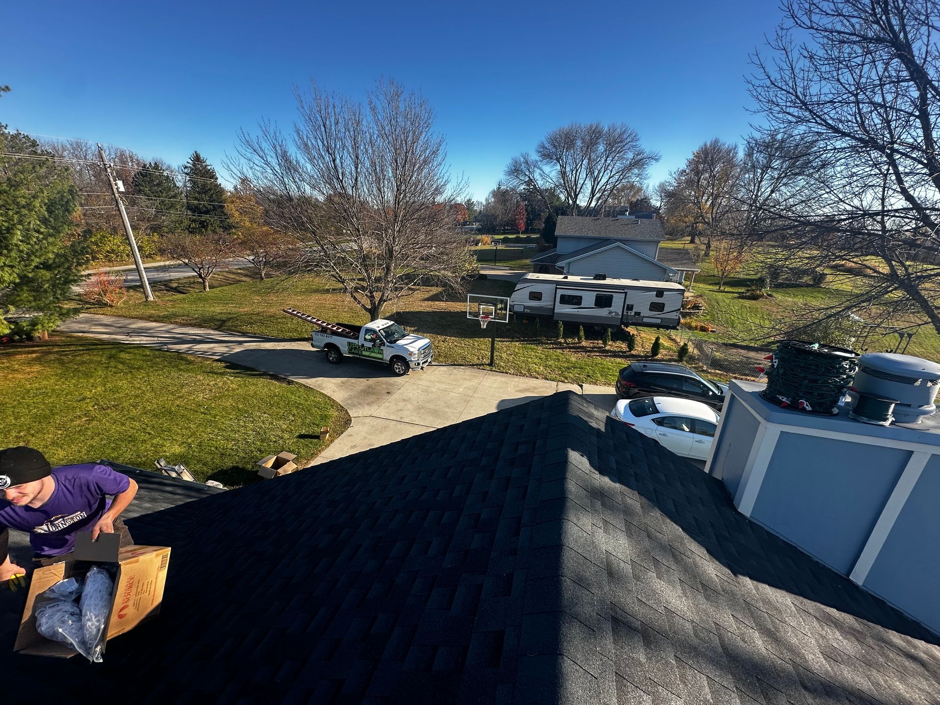 A man is sitting on the roof of a house.