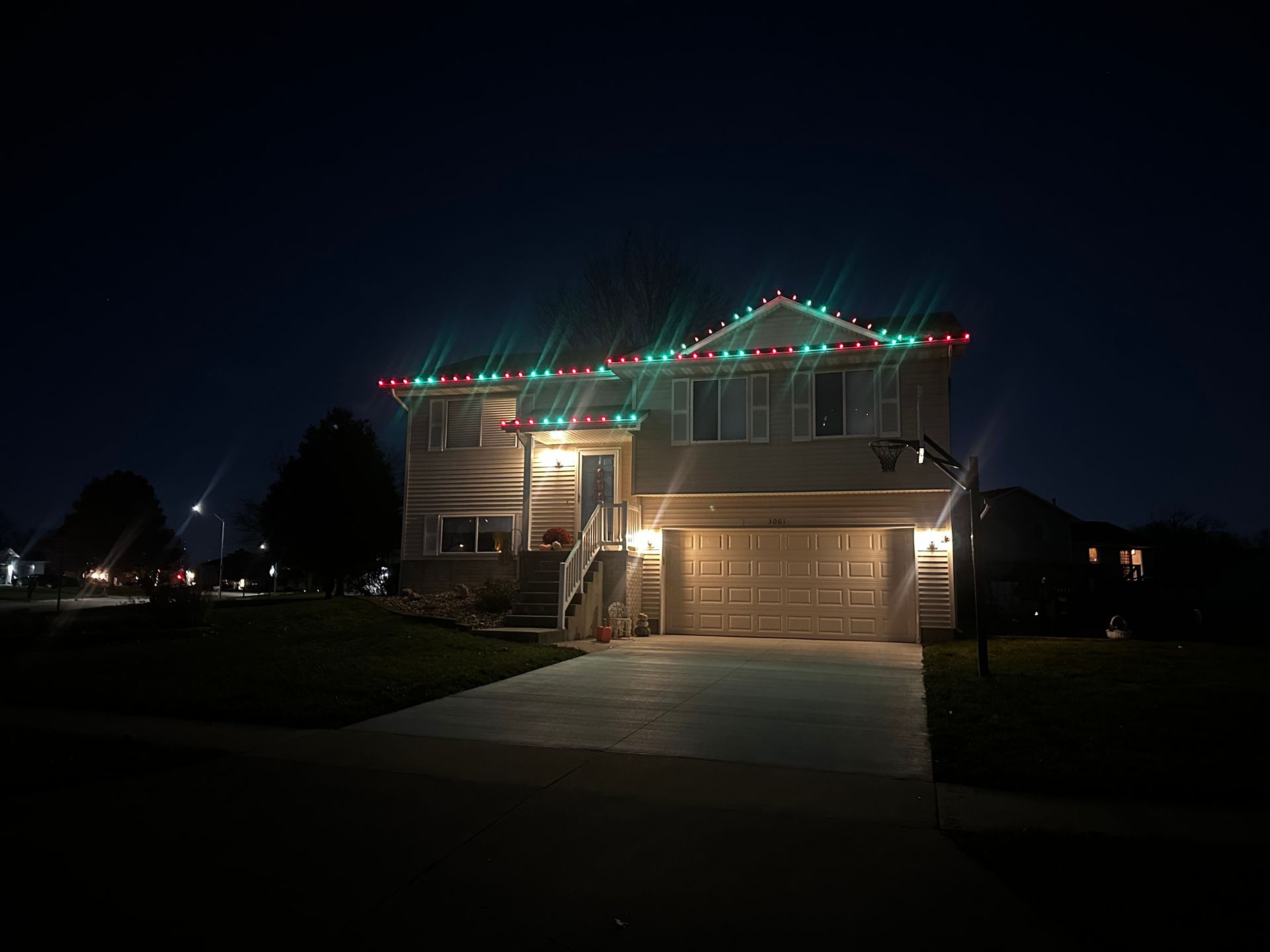 A house with christmas lights on the roof at night.