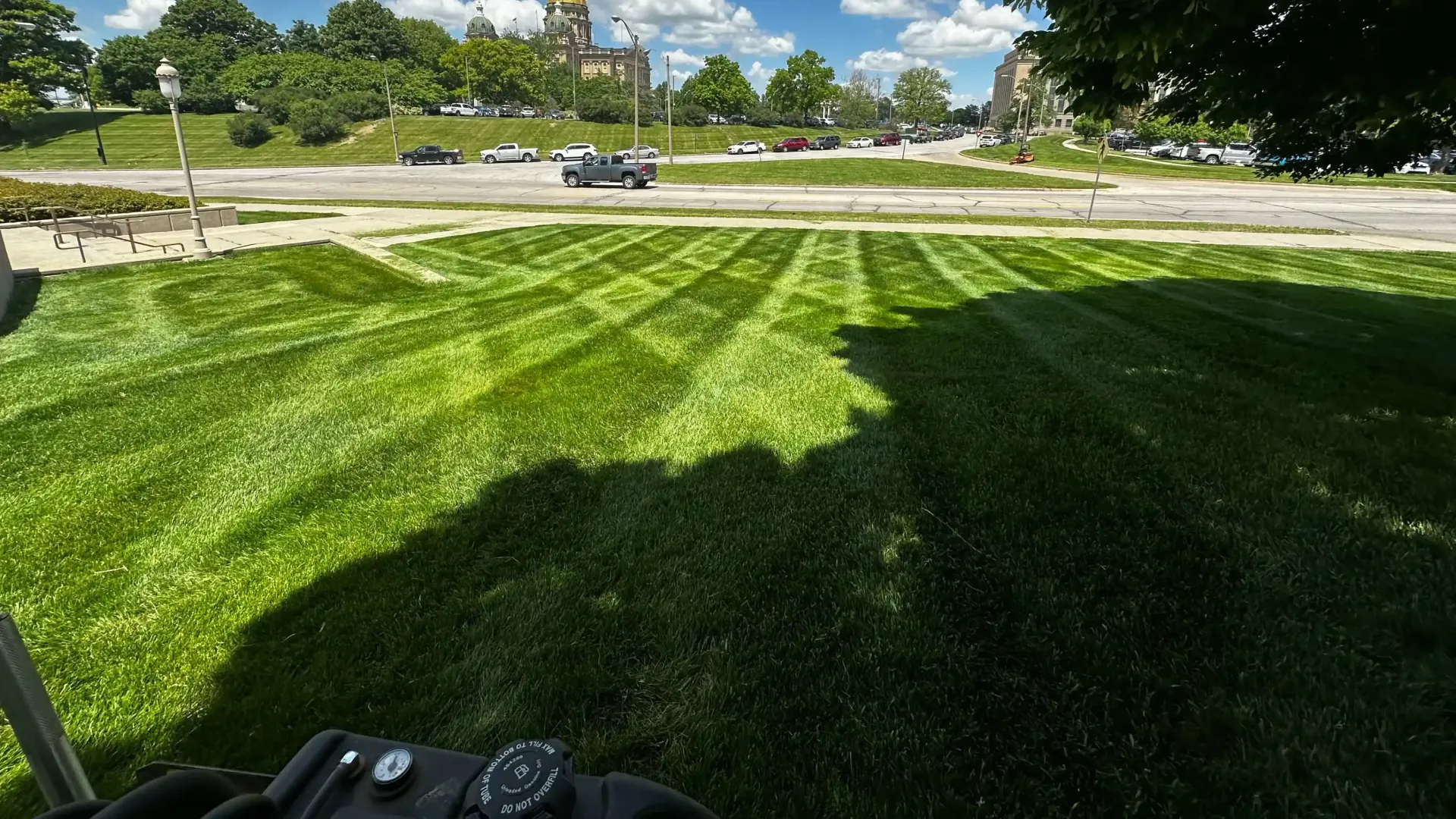 A person is sitting in a chair in front of a lush green lawn.