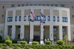A large building with three flags flying in front of it.