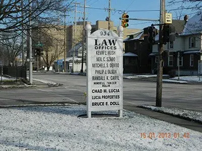 A sign for a law office is on the side of the road