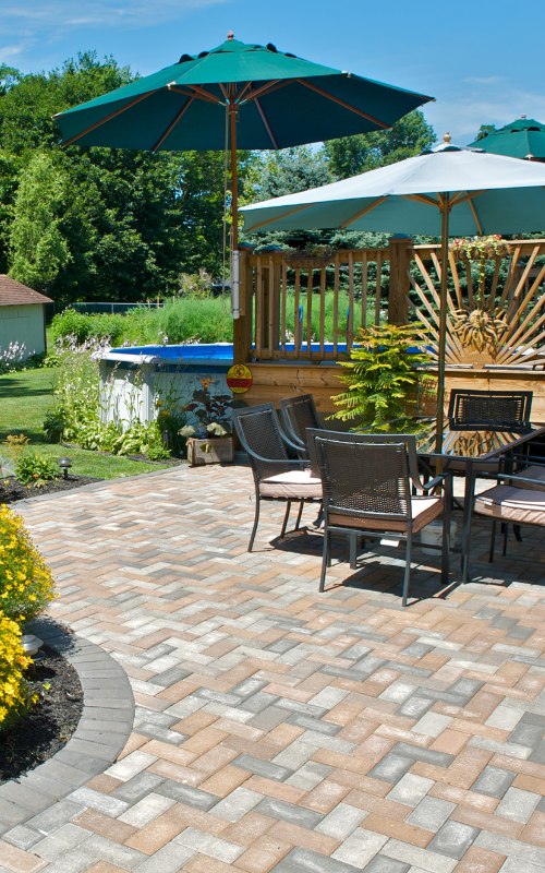 A patio with a table and chairs and umbrellas on a sunny day.