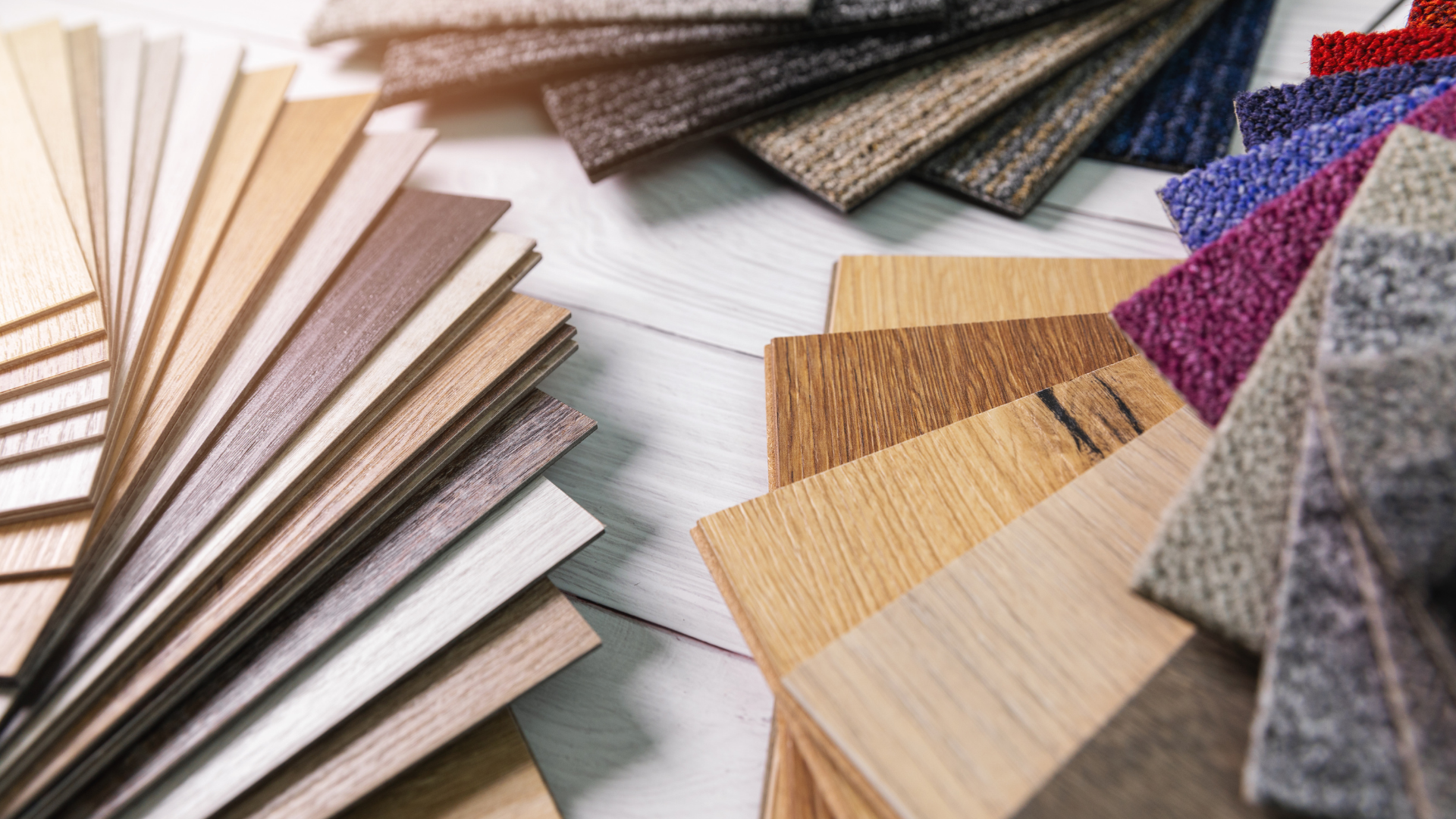 There are many different types of wood and carpet samples on the table.