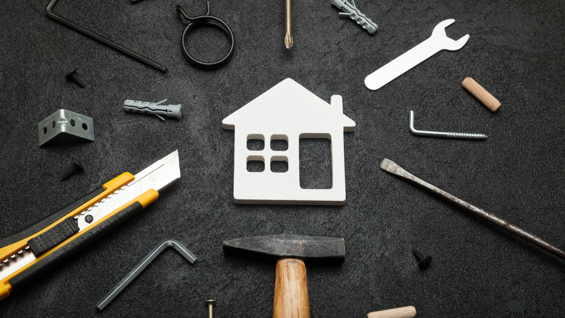 White house cutout surrounded by various tools on a dark background.