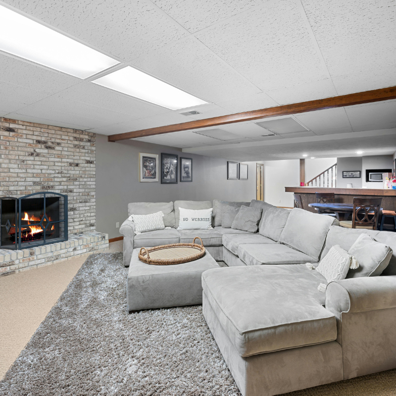 A living room with a sectional couch and a fireplace