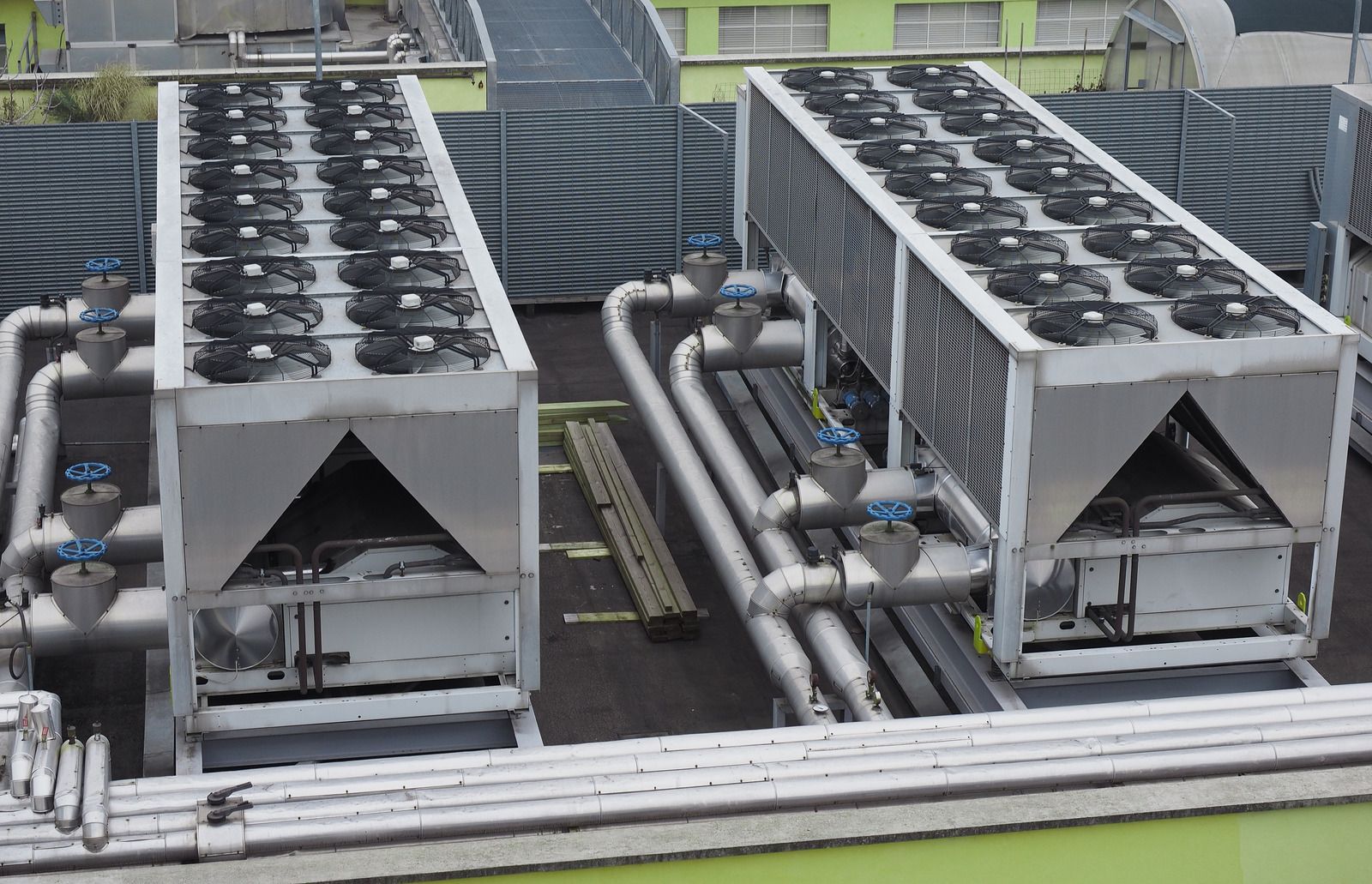 Two large rooftop air conditioning units with multiple fans and piping.