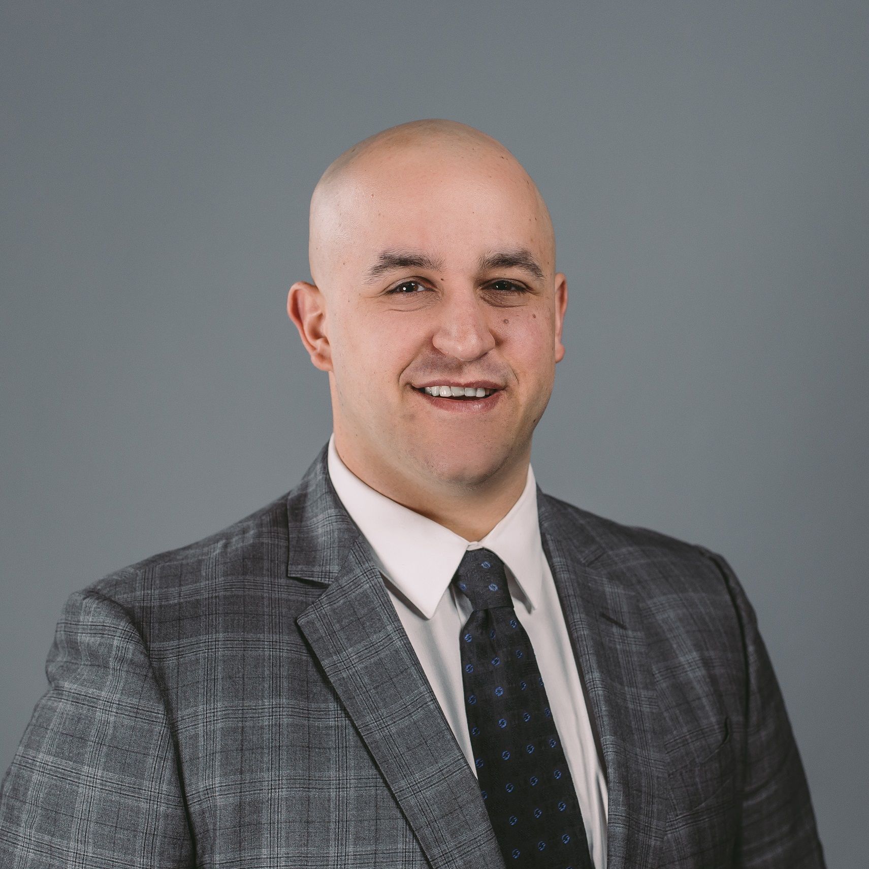A man and a woman are sitting on a dock overlooking a lake.