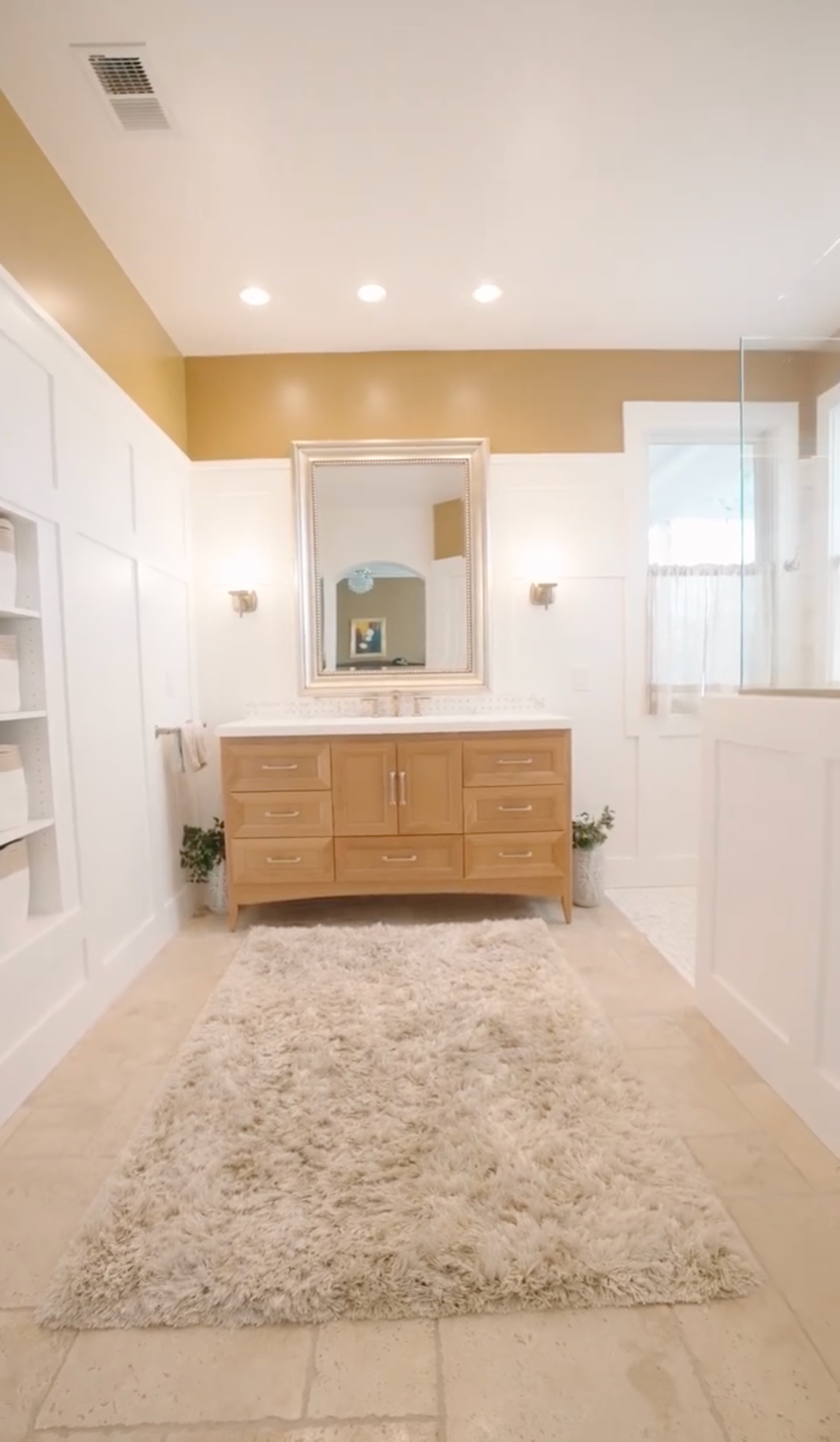 a bathroom with two sinks , a mirror and a rug .