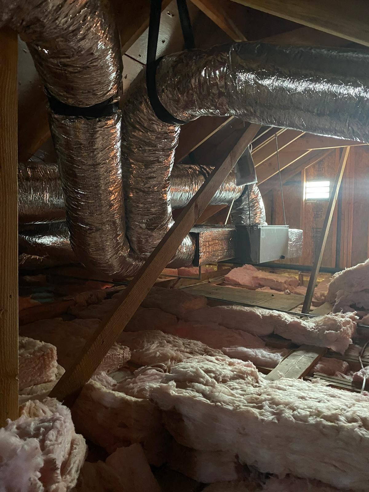 There are a lot of ducts in the attic of a house.