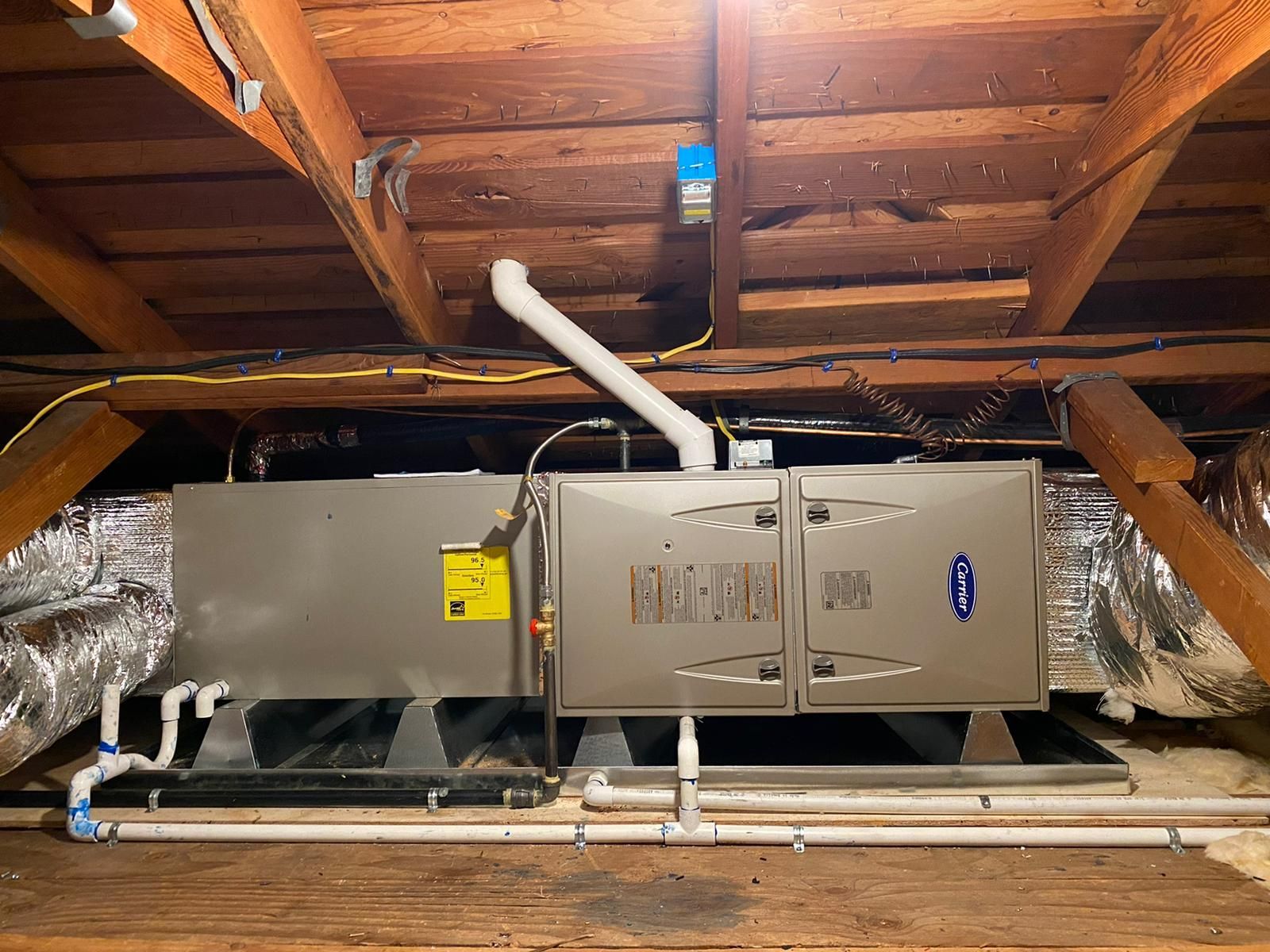 An air conditioner is installed in the attic of a house.