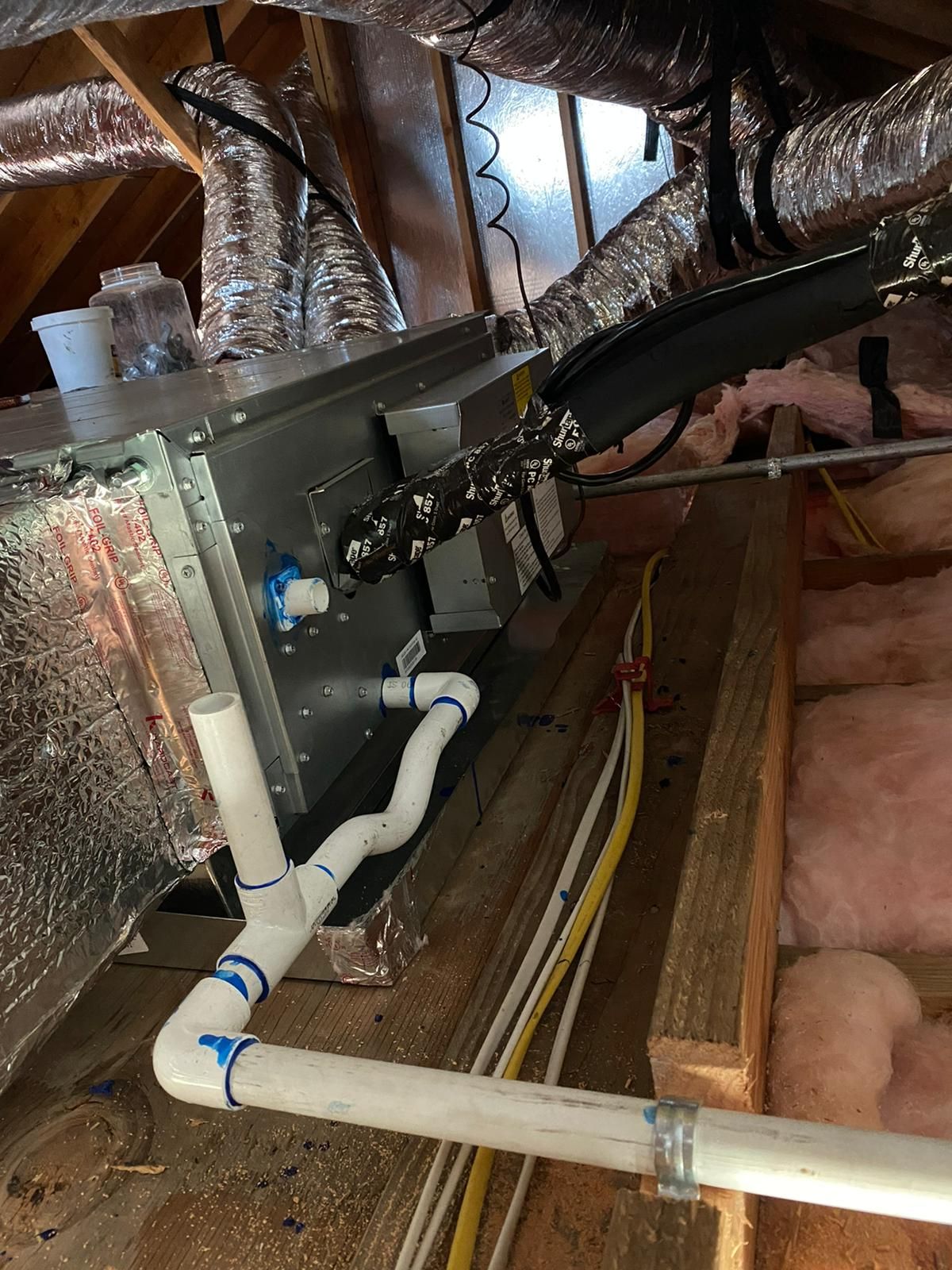 There are a lot of pipes and wires in the attic.