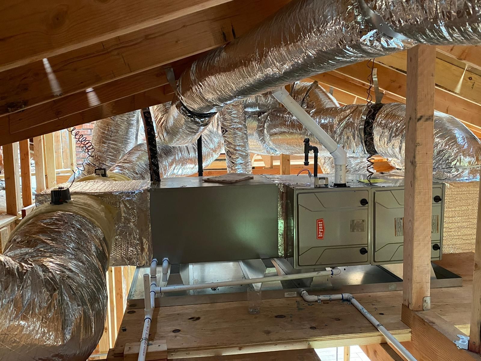 There are a lot of ducts in the attic of a house.