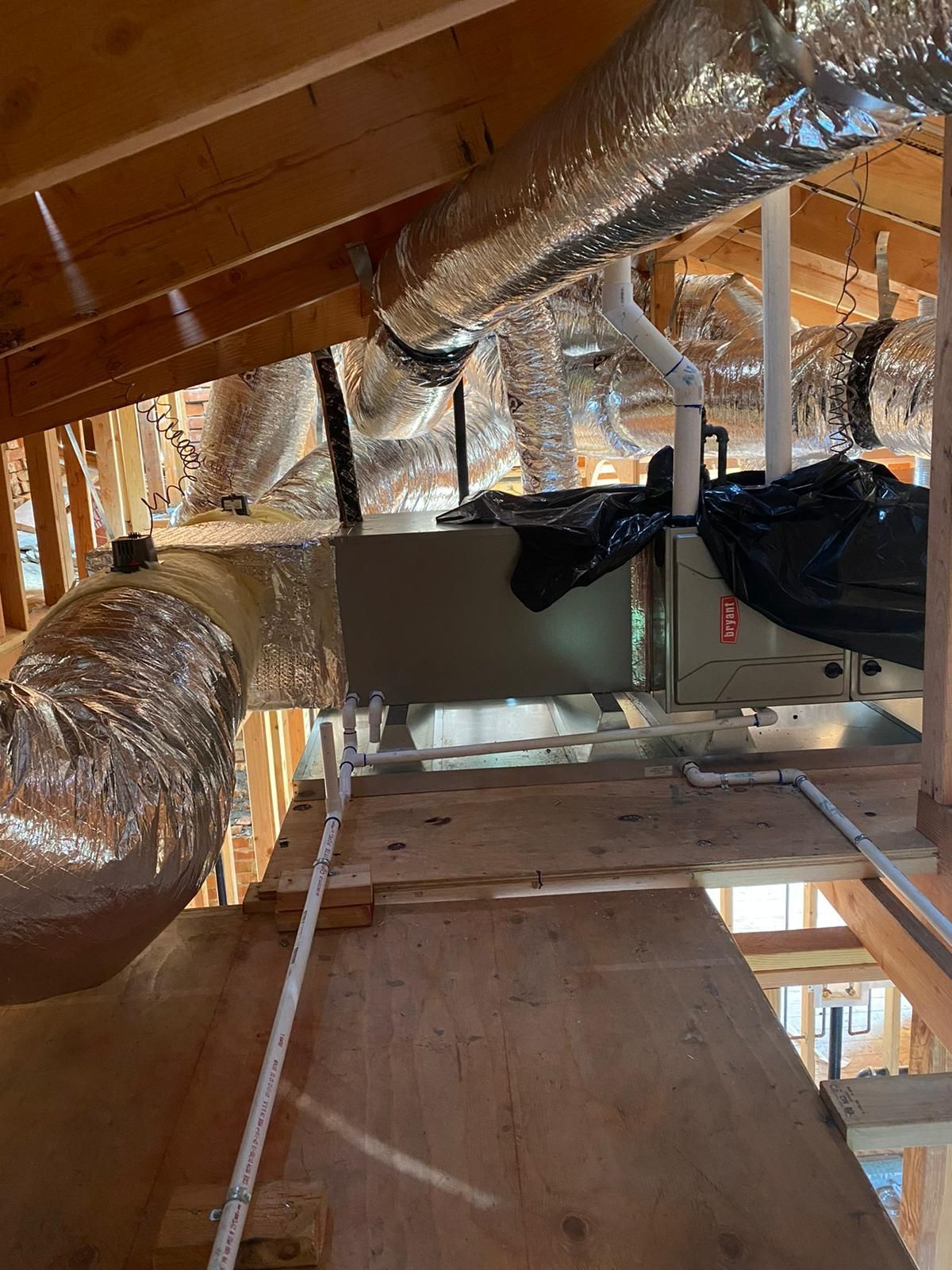 A bunch of ducts are hanging from the ceiling of a building.