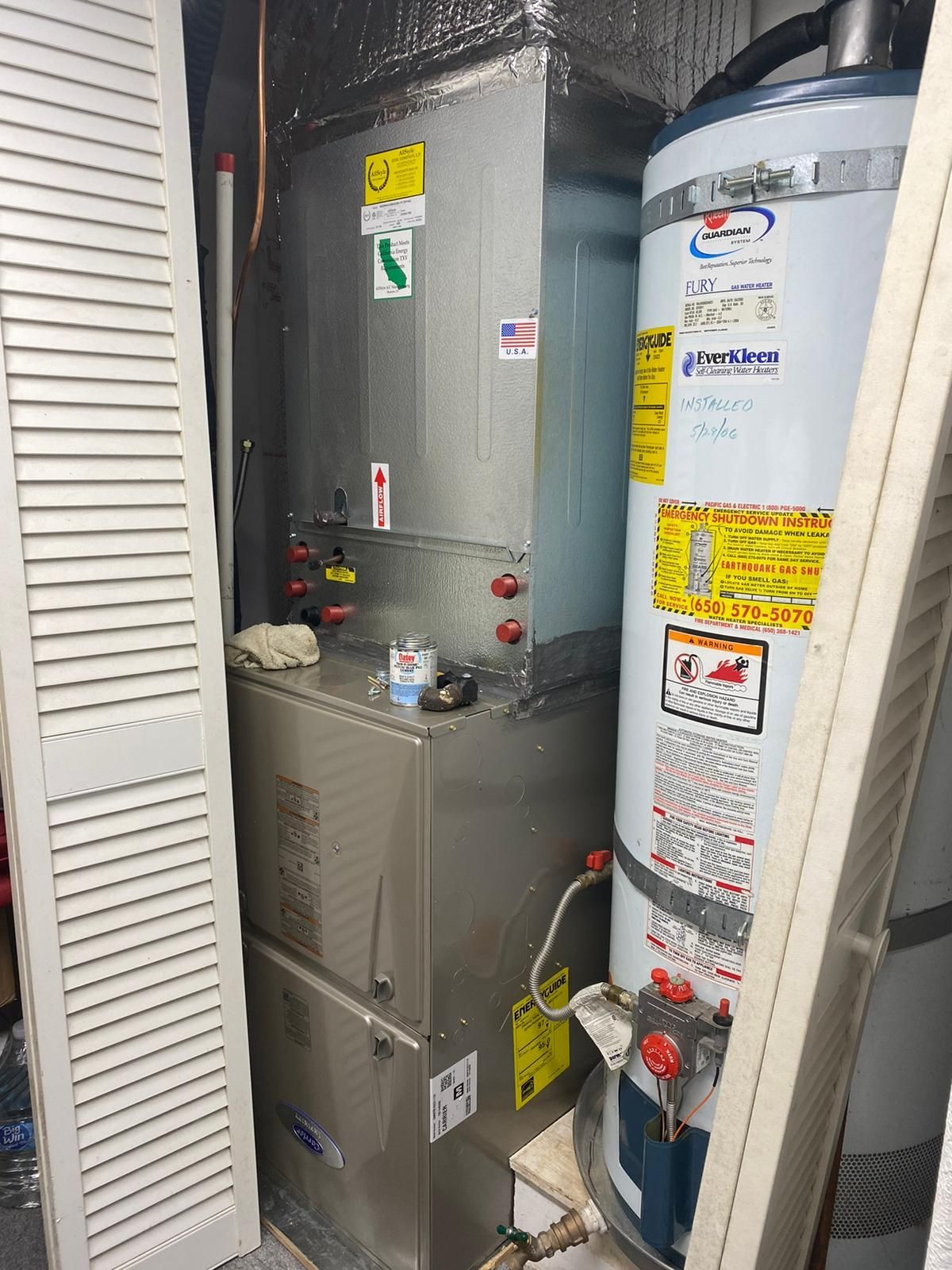 A water heater and an air conditioner are sitting next to each other in a room.