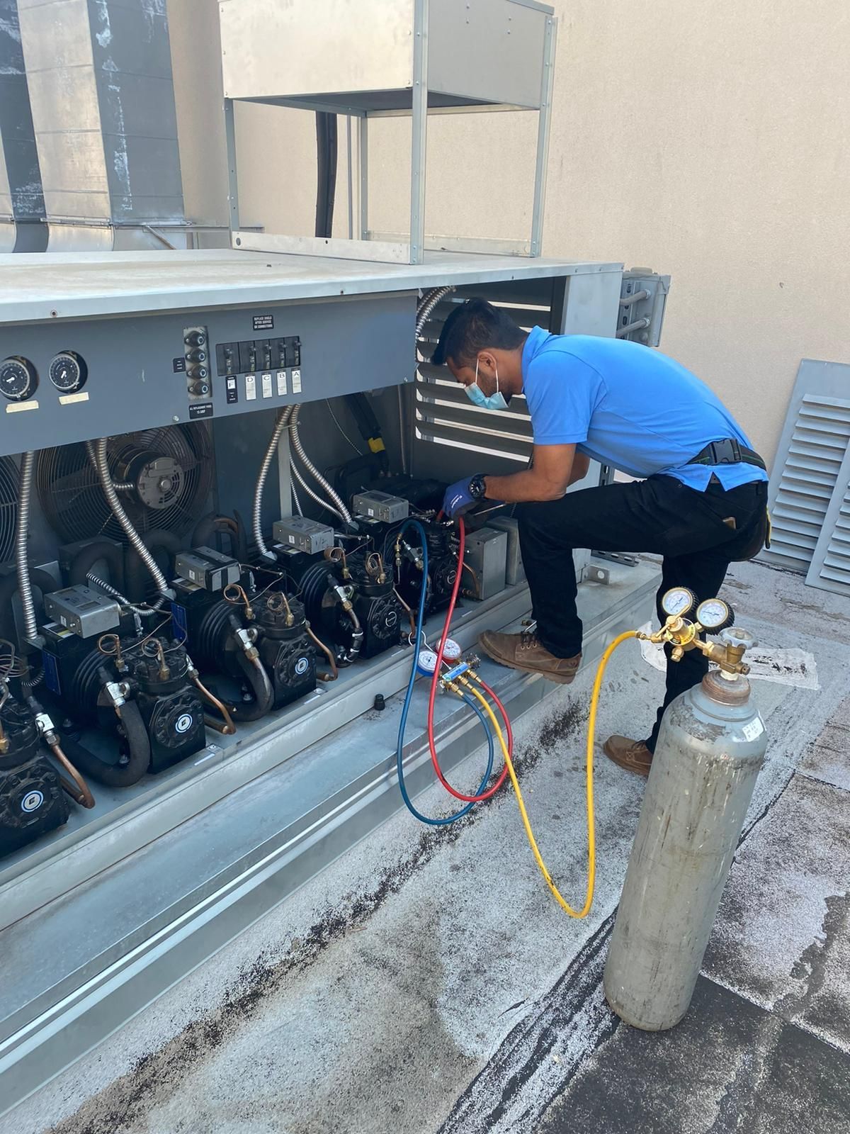 A man in a blue shirt is working on a machine.