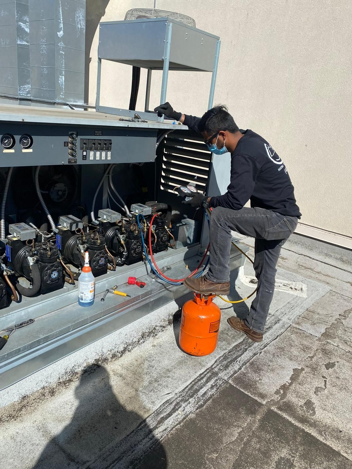 A man is working on a refrigerator outside of a building.