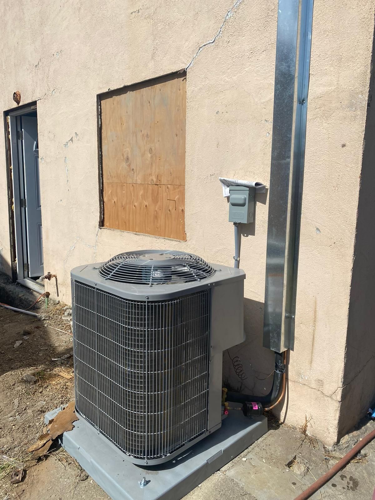 A large air conditioner is sitting outside of a building.