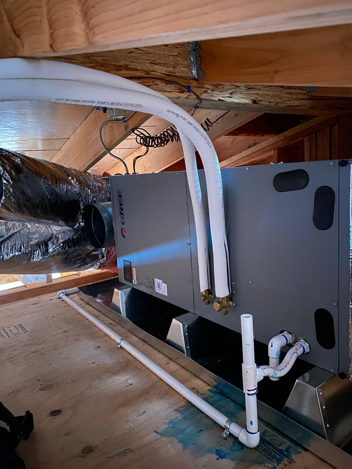 A room with a ceiling fan and pipes coming out of it.