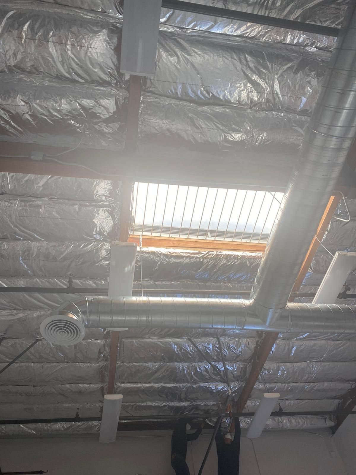 A man is working on the ceiling of a building.