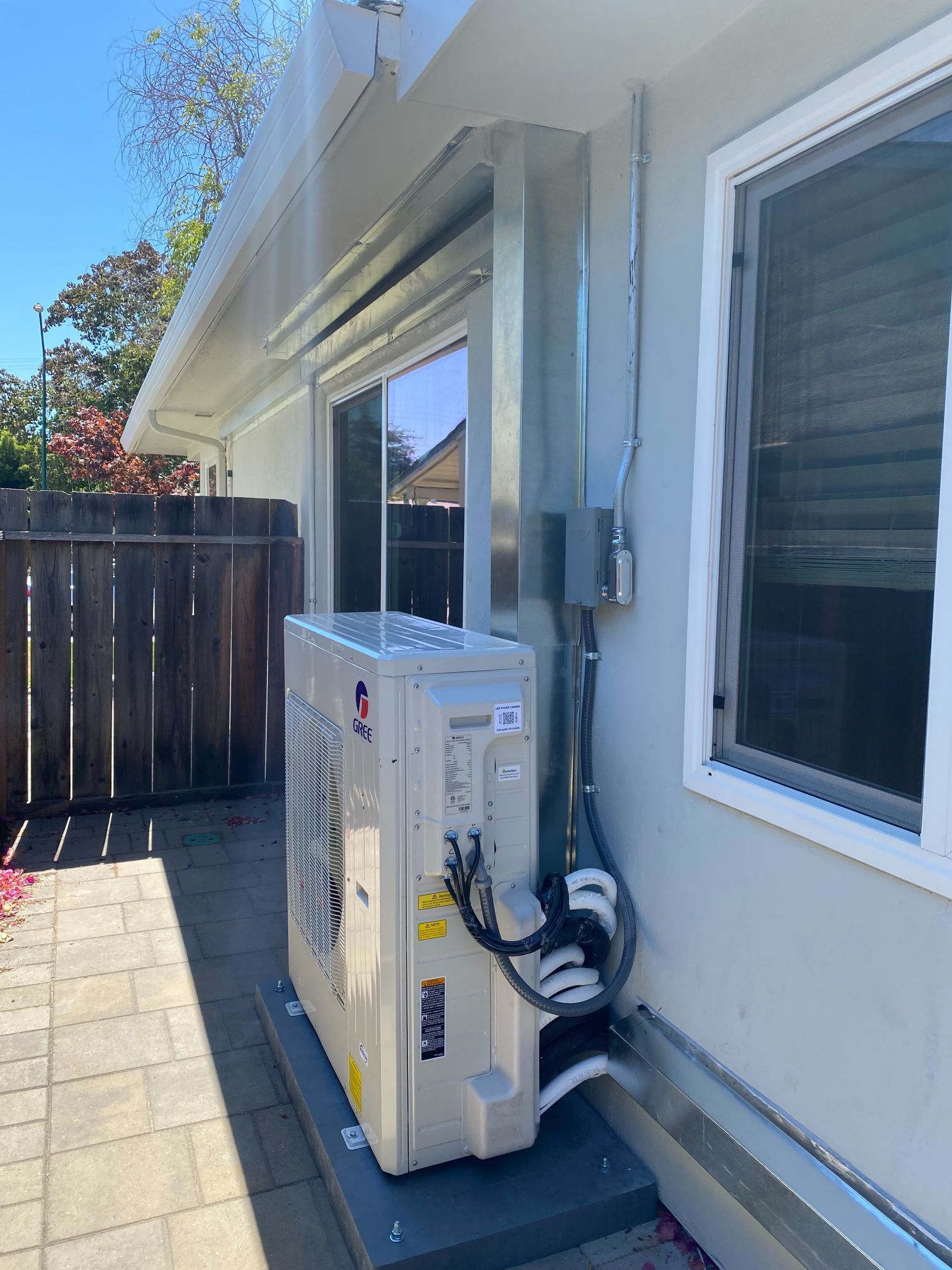 A large air conditioner is sitting on the side of a house.